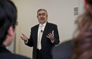 Seorang dosen menyampaikan materi kepada mahasiswa di ruang kuliah