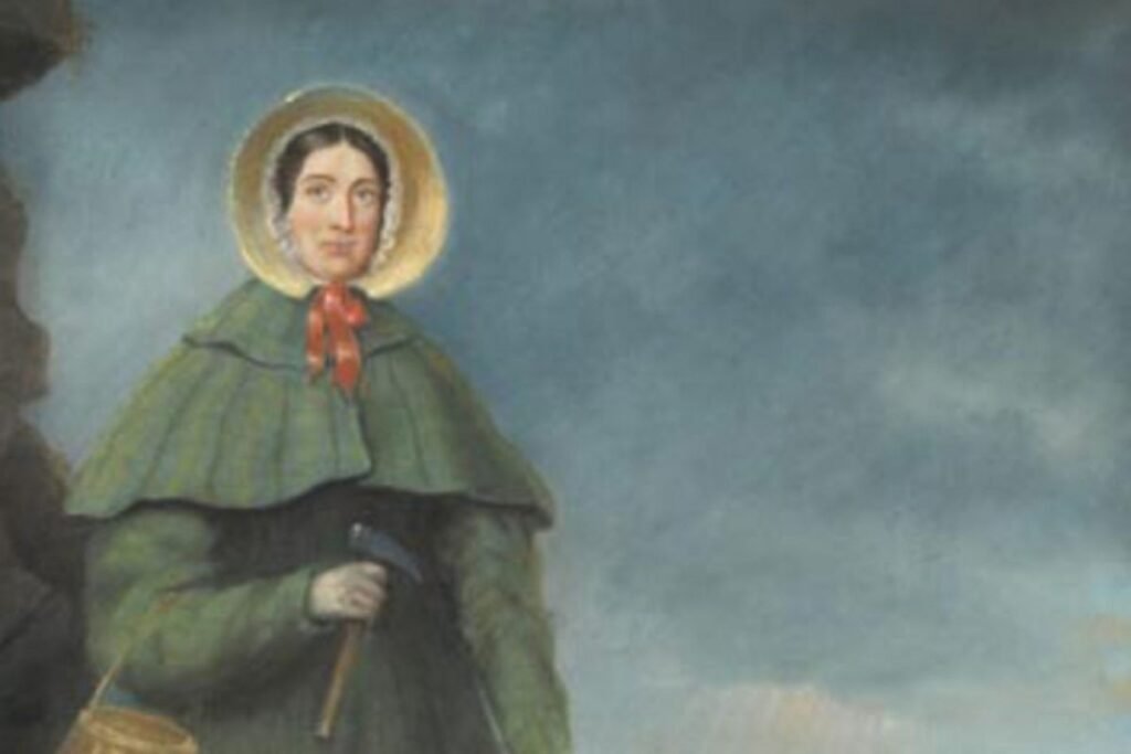 Mary Anning, seorang wanita muda, sedang mencari fosil di tebing Jurassic Coast dengan palu dan keranjang.